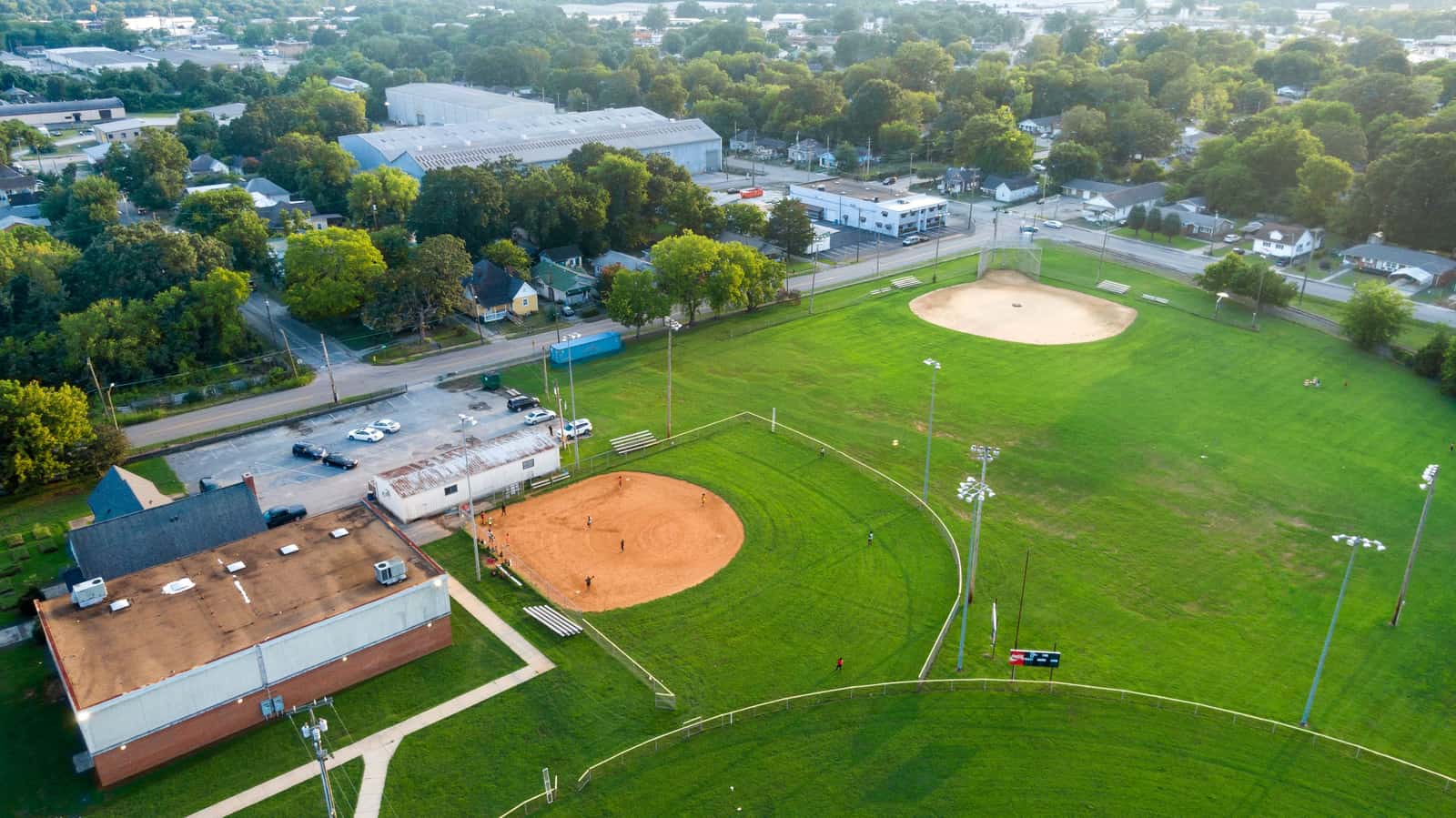 An aerial view of green baseball fields in a neighborhood