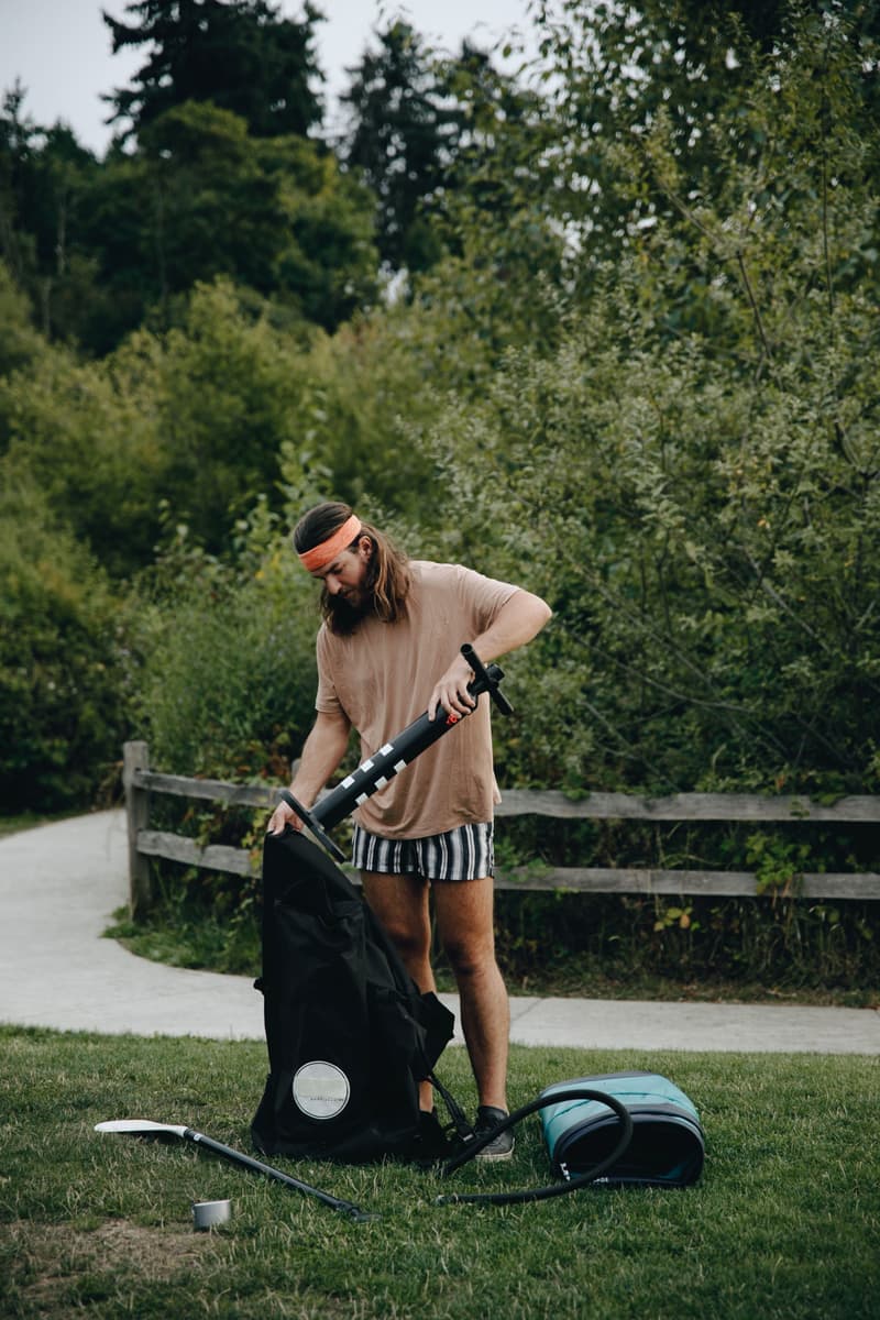 Illustrative stock photo: a man pumping up an air mattress in a park
