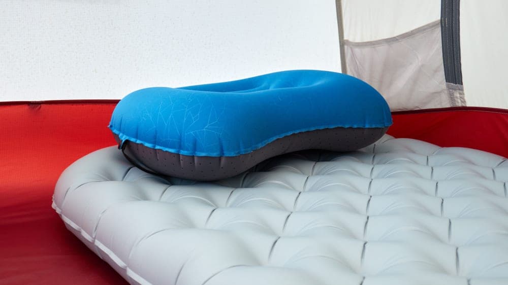 Illustrative stock photo: an inflatable pillow resting on a sleeping pad inside a tent